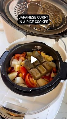 japanese curry in a rice cooker with the lid open and vegetables cut into cubes