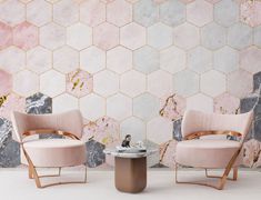 two chairs and a table in front of a wall with hexagonal tiles