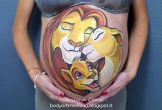 a pregnant woman's belly painted with the lion and cub family on her stomach