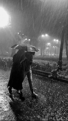 two people walking in the rain with umbrellas