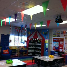 an empty classroom with colorful flags hanging from the ceiling