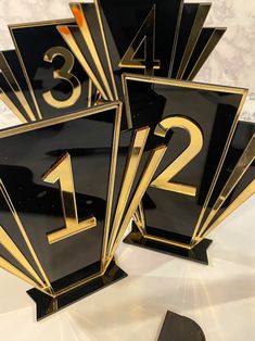 three black and gold numbers are on top of each other in front of a marble background