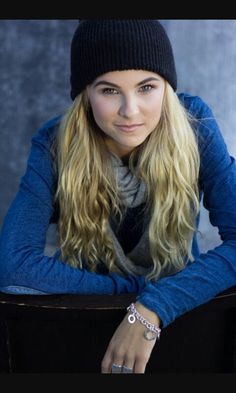 a woman with long blonde hair wearing a beanie