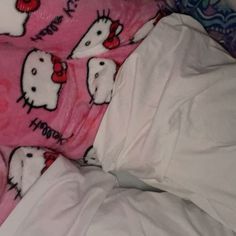 an unmade bed with hello kitty sheets on it