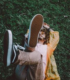 a man laying on the grass with his feet up