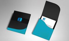 a black and blue business card holder on a gray surface with an envelope in the middle