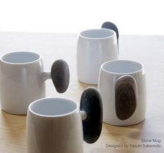 five coffee mugs sitting on top of a wooden table with black and white designs