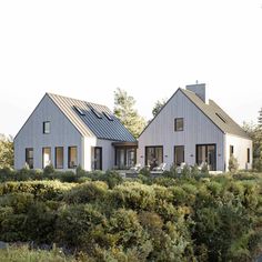 two white houses in the middle of some bushes