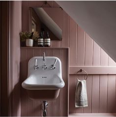 a white sink sitting under a stair case