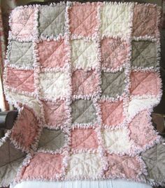 a pink and gray blanket sitting on top of a chair