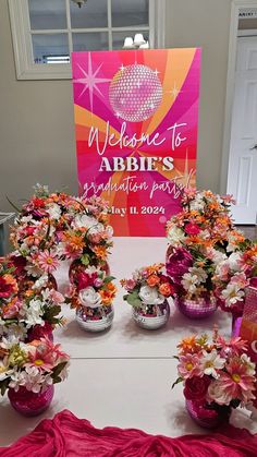 flowers in vases on a table with a welcome to abbit's sign