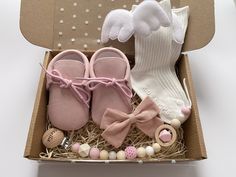 a box filled with pink baby shoes and other items next to a pair of socks