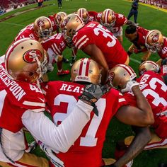 a group of football players huddle together on the field