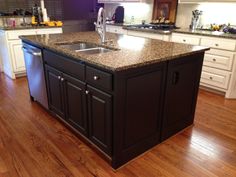 a kitchen island with granite counter tops and stainless steel appliances