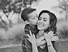 black and white photograph of a mother kissing her son