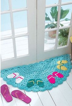 a pair of flip flops and slippers are on the floor next to a door mat