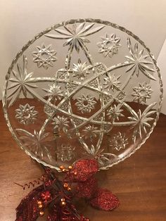 a clear glass bowl sitting on top of a wooden table next to a christmas decoration