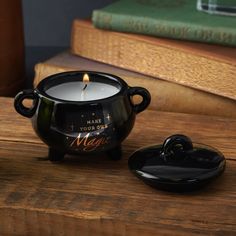 a candle that is sitting on top of a wooden table next to some books and a book