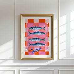 three fish are hanging on the wall in front of a pink and orange checkered background