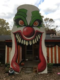 a house with a large painted clown face on it's front door and windows