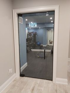 an empty room with a glass door leading into the gym