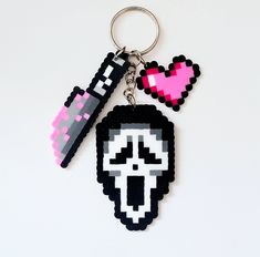 a pixel keychain with a skull and heart on it