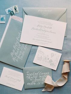 the wedding stationery is laid out on top of each other, including envelopes and cards