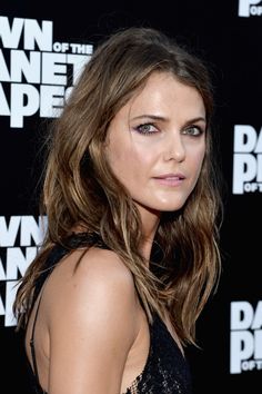 a close up of a person wearing a black dress and posing for the camera with long hair