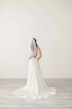 the back of a bride's dress, with her veil draped over her shoulder