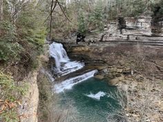 a waterfall in the middle of a wooded area