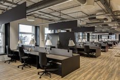 an empty office with lots of desks and chairs in the middle of the room