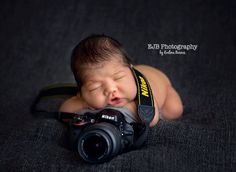 a newborn baby is posed with a camera