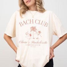 "Cabo Bachelorette Party Shirts Cocktail Club Bach Cabo San Lucas Bachelorette Shirts Beach Bach Bash Personalized Luxury Bachelorette Merch Premium Quality Printed in the USA. HOW TO ORDER ----------------------- 1-) Check and Review all Photos. 2-) Select Your T-Shirt Size from drop down menu. 3-) Choose Your Quantity you want. 4-) Click ADD TO CART. And, you can go back to add more product for your family members or You can complete the checkout process. 5-) Please Click \"Proceed to Check Out\" 6-) Your order will be ready to ship 2-5 Business Day. ABOUT US --------------- We are a husband-and-wife team who believe that beauty is all around us, and we strive to capture it in our designs. Thank you for choosing to shop with us, and we hope you find something that inspires you! For custo Summer Bachelorette Party Crew Neck Shirt, Summer Bachelorette Party Shirt With Graphic Print, Summer Graphic Print Shirt For Bachelorette Party, Graphic Print Shirt For Summer Bachelorette Party, Graphic Print Shirt For Bachelorette Party In Summer, Summer Crew Neck Shirt For Bachelorette Party, Crew Neck Shirt For Bachelorette Party In Summer, Casual Summer Tops For Bachelorette Party, Cabo San Lucas Bachelorette