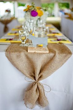 an image of a table setting with place settings on the table and flowers in vases