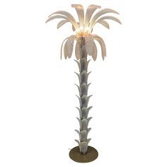 a lamp that is sitting on top of a stand with a plant in the middle