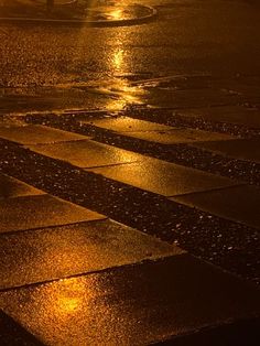 the street is wet with rain and it's lights reflecting off in the puddles