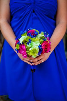 a woman in a blue dress holding a bouquet of flowers