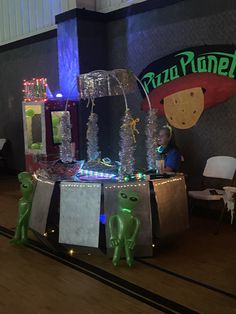 an ice cream parlor with neon lights and decorations on the counter, along with plastic alien figurines