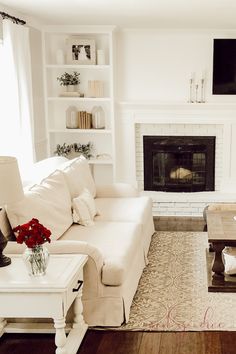 a living room filled with furniture and a fire place under a tv mounted above a fireplace