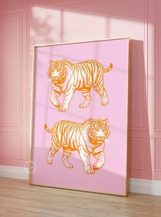 two orange tigers on pink wall next to wooden floor