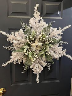 a wreath is hanging on the front door with snowflakes and berries around it