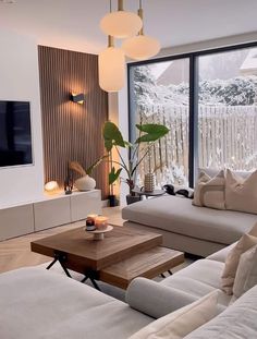 a living room filled with furniture and a flat screen tv mounted on the wall next to a window