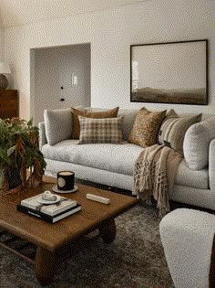 a living room filled with furniture and a coffee table in front of a painting on the wall