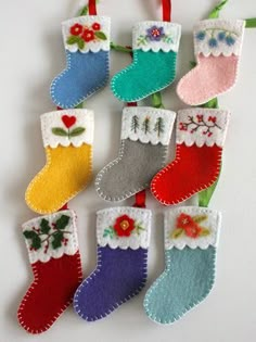 felt christmas stocking ornaments with flowers and hearts hanging on a line from the top