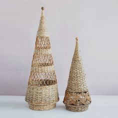 two wicker christmas trees on a white table