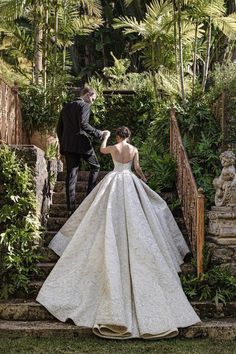 the bride and groom are walking down the stairs