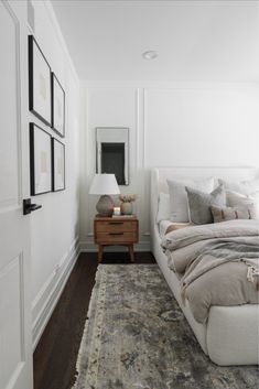 a bedroom with white walls and wood floors