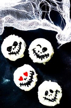 three decorated cookies sitting on top of a black table next to a netted bag