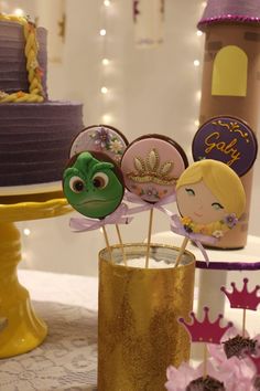 there are cake toppers in the shape of princesses and frog heads on sticks