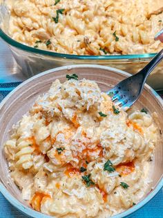 two bowls filled with macaroni and cheese on top of a blue table cloth